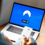 macbook pro on brown wooden tablewith logo of nordvpn