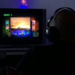 a man sitting in front of a tv with headphones on
