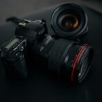 black Canon DSLR camera beside camera lens