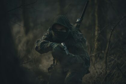 person in black and white hoodie holding rifle