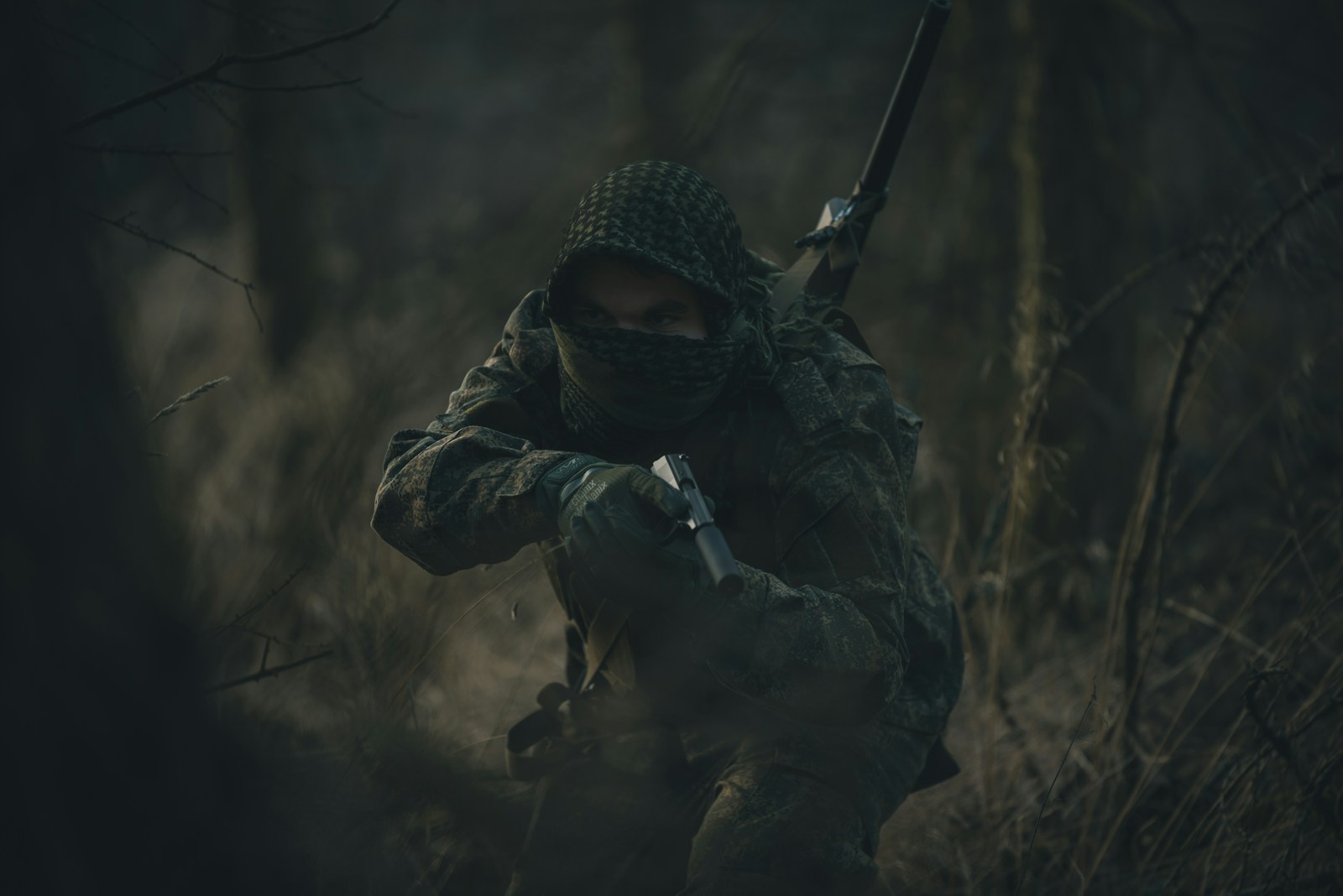 person in black and white hoodie holding rifle