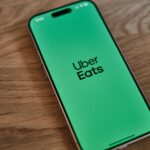 A green iPhone sitting on top of a wooden table