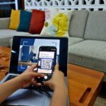 a person using a laptop computer with a qr code on the screen