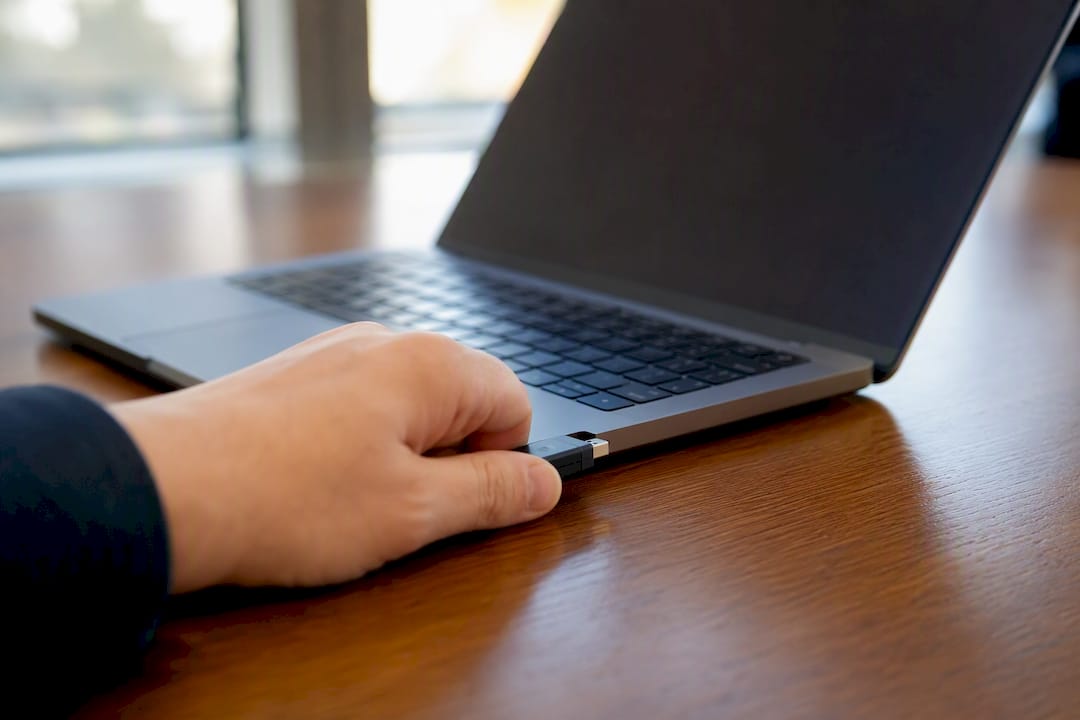 Hand inserting USB security token into laptop