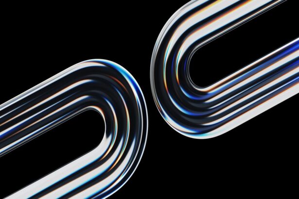 Two curved metallic objects reflect light on black